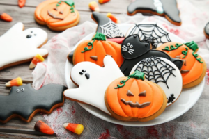 Halloween-themed cookies on a table scattered with candy corn